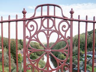 The decorative ironwork found in the centre of the world's first Iron Bridge in Ironbridge, Telford, Shropshire. The design features a central circle, surrounded by flowing loops and neighboured by railing. The central section is adorned with the type 'ERECTED 1779'.