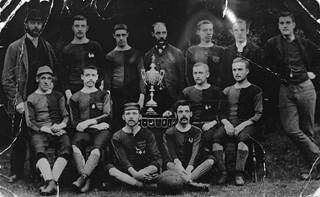 Black and white photograph of St Georges Football Team early 1880s with trophy and medals