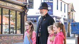Constable Jarret Posing for photos on the corner of Blists Hill Canal Street High Street with 3 girls wearing pink.png